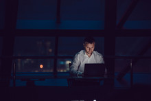 Businessman Working On Laptop In Night Office.