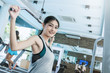 © paulaphoto - Attractive young asian woman working out with exercise machine at the gym, asian beautiful girl in sportswear is engaged in fitness sport club