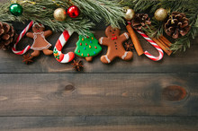 Christmas Background. Different Shapes Of Gingerbread Cookies And Christmas Decorations On A Wooden Backdrop. Copy Space And Top View.