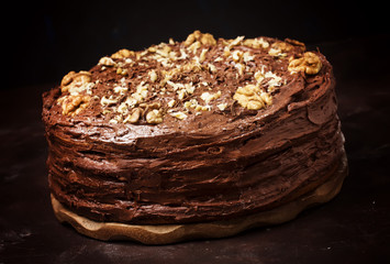 Wall Mural - Homemade chocolate cake with nuts, black background, selective focus