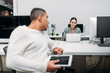 © LIGHTFIELD STUDIOS - multiethnic young business partners talking at office