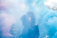 Young Woman With Colored Smoke Bombs