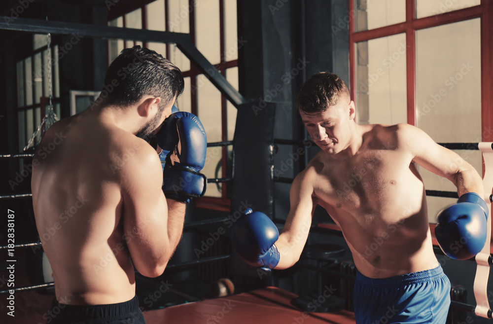 Young professional boxers training in ring