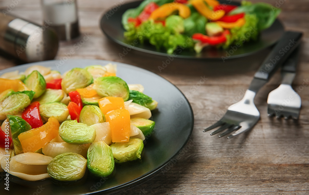 Plate of pasta with Brussels sprouts on table