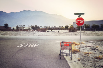 Abandoned shopping cart on a street at sunset, color toned picture, USA.