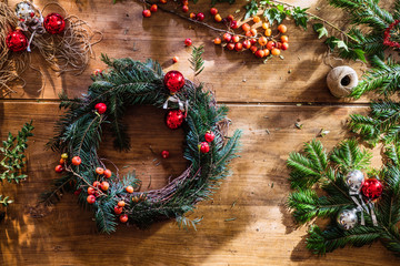 Wooden table with a Christmas crown and Xmas decorations.