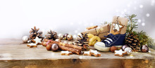 St. Nicholas Day, German Nikolaus, Wide Panoramic Format With Kid Shoe, Sweets And Gifts  On Rustic Wood, Background With Copy Space And Blurry Lights Fades To White