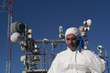 © karrastock - Man who works in a white suit and blue gloves, antennas