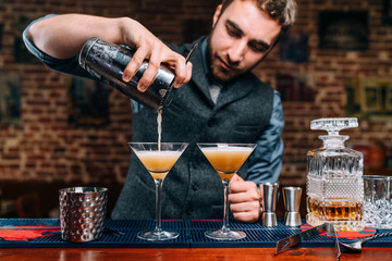 Wall Mural - Close up details of barman pouring fancy alcoholic drinks at party