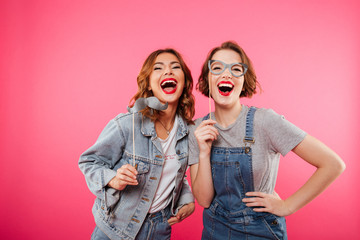 Poster - Funny women friends holding fake moustache and glasses.