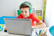© Syda Productions - boy in headphones playing video game on laptop