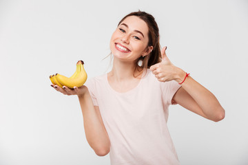 Poster - Portrait of a smiling young girl holding bananas