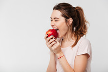 Close Up Portrait Of A Hungry Girl Biting An Apple