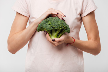 Poster - Close up of a woman holding broccoli