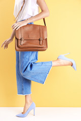 Poster - Young woman in stylish shoes against color wall