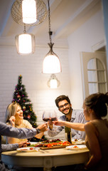 Young people celebrating New Year and drinking red wine