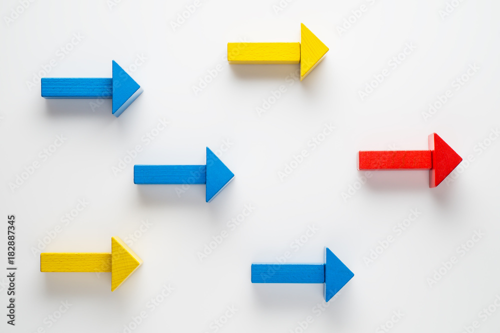 Wooden arrows on white background, one arrow in opposite direction from others. The concept of independent thinking, individuality, uniqueness. Business concept, another way. - obrazy, fototapety, plakaty 
