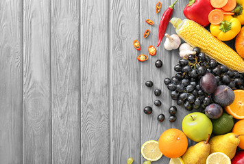Fototapete - Various fruits and vegetables on wooden background