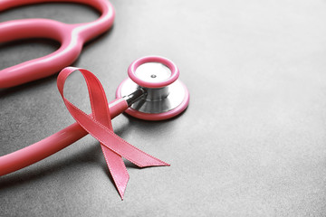 Poster - Pink ribbon and stethoscope on gray table. Breast cancer concept