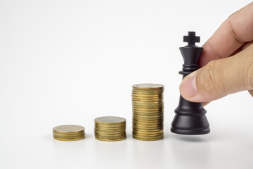 Coins stack and chess on white background with save money and game business ,the strategy investment with your money.