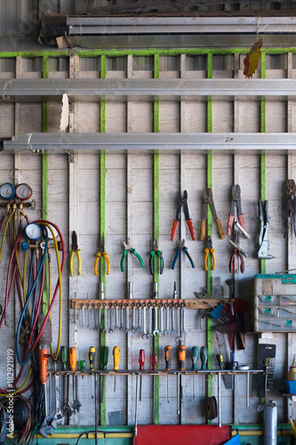 Old Hand Tools Hanging On Wall In Workshop Or Auto Service Garage