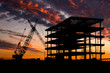 Steel construction site at sunset with a crane.