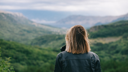 Beautiful girl on top of mountain watching scenery