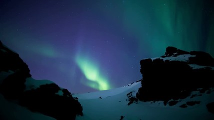 Wall Mural - aurora borealis moving over snowy volcanic mountain pass reykjavik iceland.mov