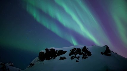 Wall Mural - brilliant strong aurora borealis over snow covered rocky terrain reykjavik iceland.mov