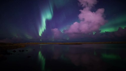deeply colorful aurora borealis night sky reflecting in calm lake water iceland 4k.mov