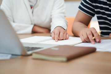 close up teacher pointing on notebook for teaching lesson to student (one by one) before test examin