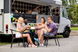 © Syda Productions - happy friends with drinks eating at food truck