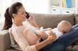 mother with baby calling on smartphone at home