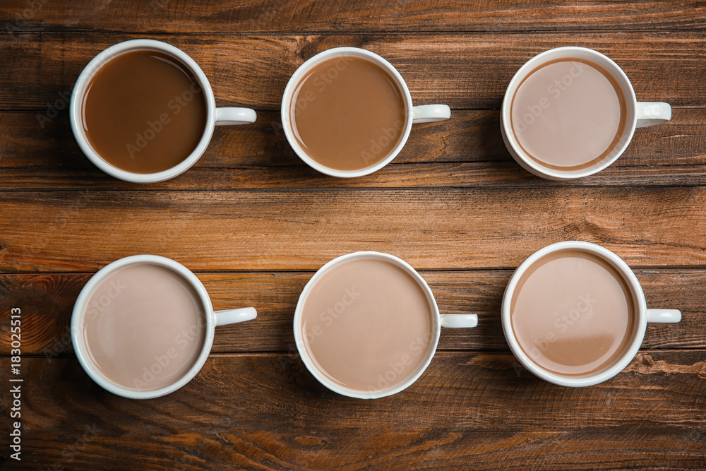Cups with delicious coffee on wooden background