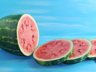 Wall Mural - green watermelon cut into round slices on a blue  background