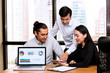 © Sasils Production - Future business leader concept. Group of young business team discussing work together in modern office with notebook screen in foreground.