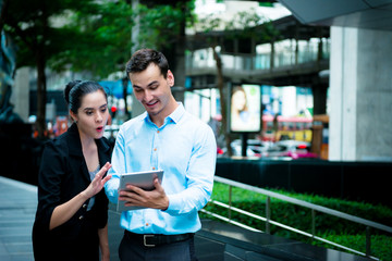 Young business leaders concept. Young Business man discussing work with woman co worker outdoor in city.