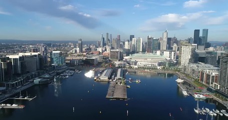 Wall Mural - Rotation in Melbourne Docklands suburb above Yarra River waters from amusement observation wheel to city CBD skyscrapers and buildings.
