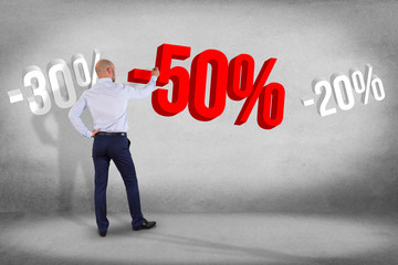 Poster - businessman in front of a wall with sales promotion 20% 30% and 50% flying on an interface - shoppin