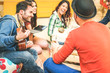 © Alessandro Biascioli - Group of friends having fun in living room in their home - Happy young people playing music with guitar and tablet singing and laughing together - Soft focus on male on left