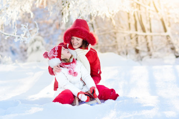 Wall Mural - Mother and child sledding. Winter snow fun. Family on sleigh.