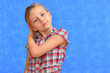 Studio shot of young preteen 9-10 year old redhead girl wearing heart shape sunglasses, standing against blue purple background, big thumbs up