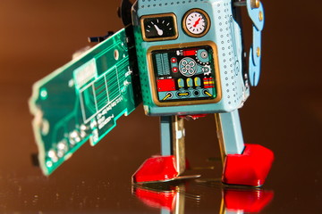 Tin toy robot carries computer circuit board, artificial intelligence concept