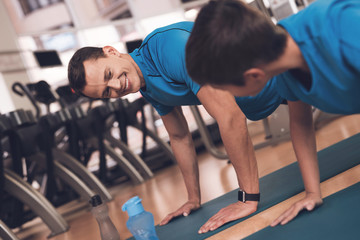 Wall Mural - Dad and son in the same clothes in gym. Father and son lead a healthy lifestyle.