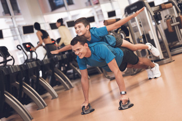 Wall Mural - Dad and son in the same clothes in gym. Father and son lead a healthy lifestyle.