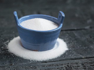 Sea salt fine grind the shaker blue on a rustic table.