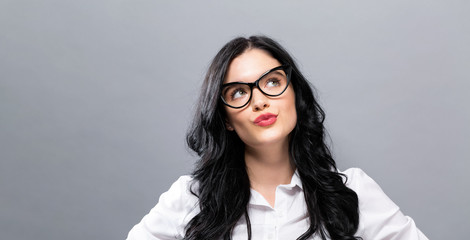 Young businesswoman in a thoughtful pose on a solid background