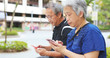 © leungchopan - Retired couple using mobile phone together