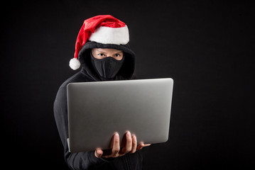 Wall Mural - mysterious male santa hacker holding laptop computer
