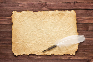 Wall Mural - White feather and old paper on wood surface